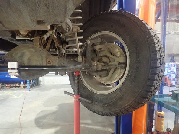 Lift the vehicle off the ground, then turn the wheels fully left. Make sure the left wheel steer stopper touch frame as shown by yellow circle.