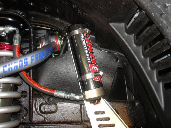 Sit reservoir into bracket, locating it as high as possible while aligning the hose as close to the chassis as possible.