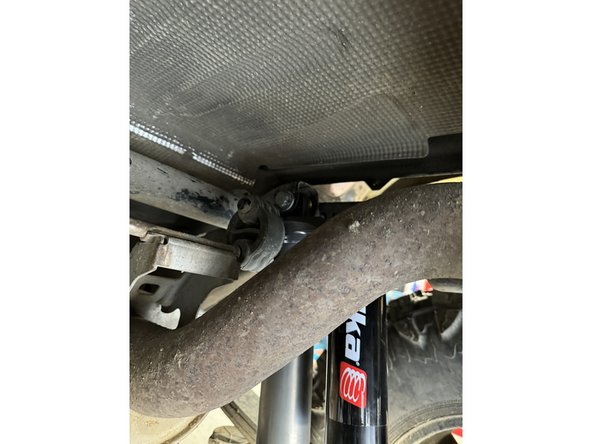 Using an underhoist stand or a jack, lift rear axle to be able to install lower bolt.