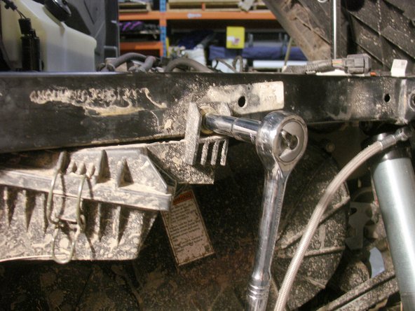 Remove the bolt holding the air box to allow enough clearance to slide in the provided reservoir collars.