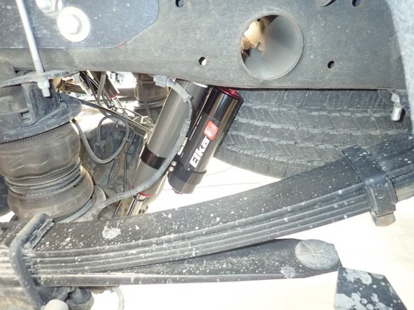 Install upper OEM bolt, Push on shock rod end to compress shock and install lower bolt. Tighten all bolts at 100 ft.lb.