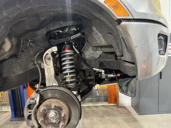 Install the Elka shocks using provided lower and upper bolts. Hoses must face the front of the vehicle as shown.