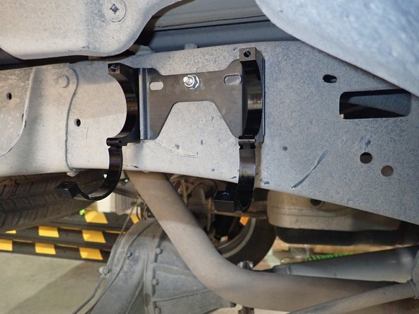 Install reservoir bracket with first supplied bolt in the hole already in frame at the right side of shock (right side shown)