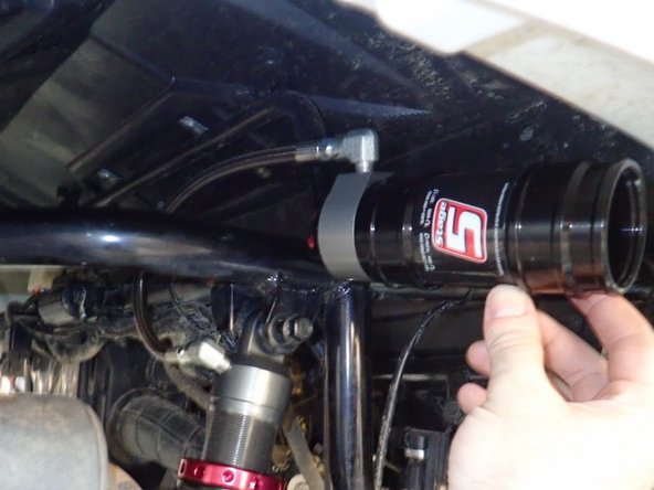 Install shocks with hose fitting facing Inside the frame (right side shown).