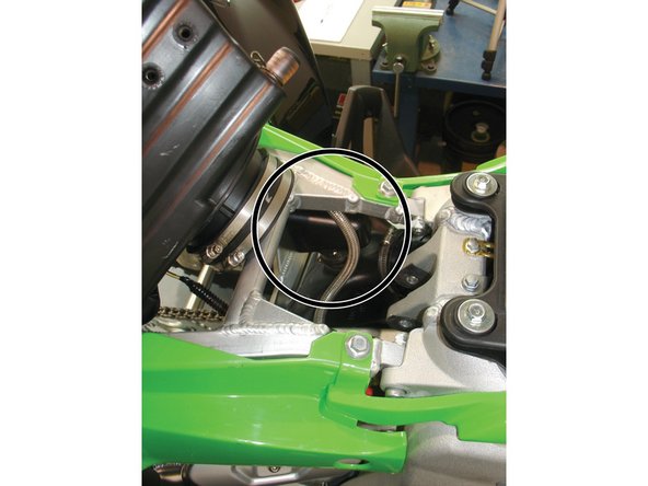 Route the reservoir’s hose above the small airbox chamber, pulling out the reservoir through the left side of the rear subframe. Attach the shock to the upper mount using the stock bolts.