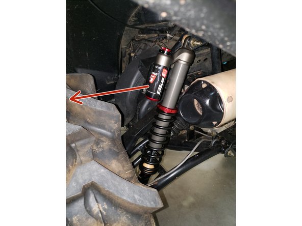 Install the left and right new Elka rear shock with the piggyback reservoir at the top (stage 3,4,5) and oriented towards the exterior of the vehicule as indicated by the red Arrow on the photo.