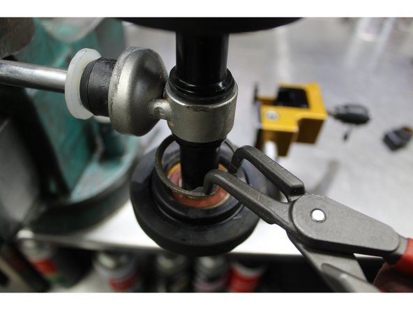 Remove the circlips and remove the idler wheel off one side of your centre shock assembly.