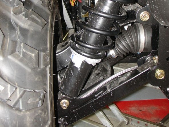 Remove the top and bottom shock bolts and then remove the stock shock.