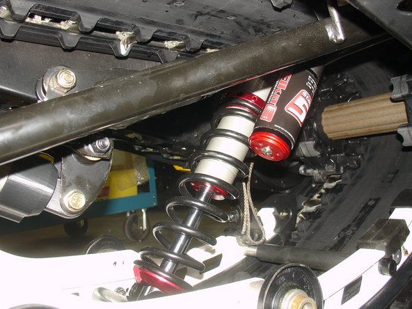 The lower shock eyelet rebound adjuster screw must be oriented toward the rear of vehicle,