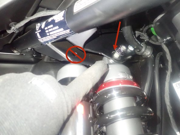 The upper bolt of shock must be installed in the inner frame hole as shown by the red Arrow.