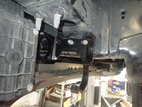 Slide bolt into the  frame hole as in the previous step and fix the bracket with the larger washer and supplied nut. Torque nut to 20 Ft-Lb.