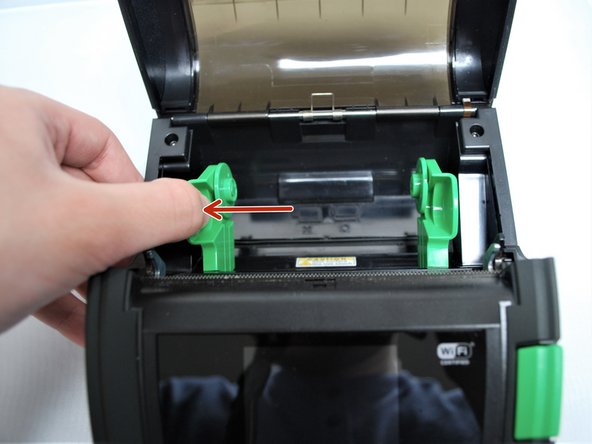 With one hand, pull the media holder open, and with the other hand load the roll of labels.