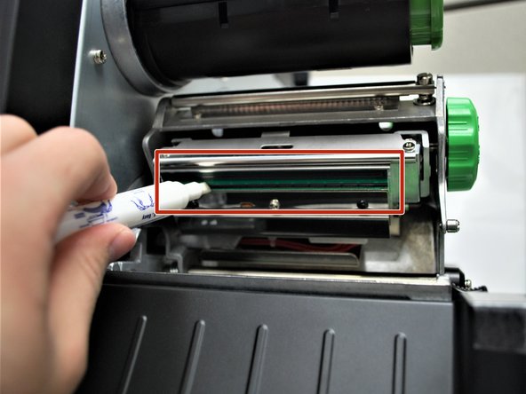 With the other, rotate the green release lever clockwise.