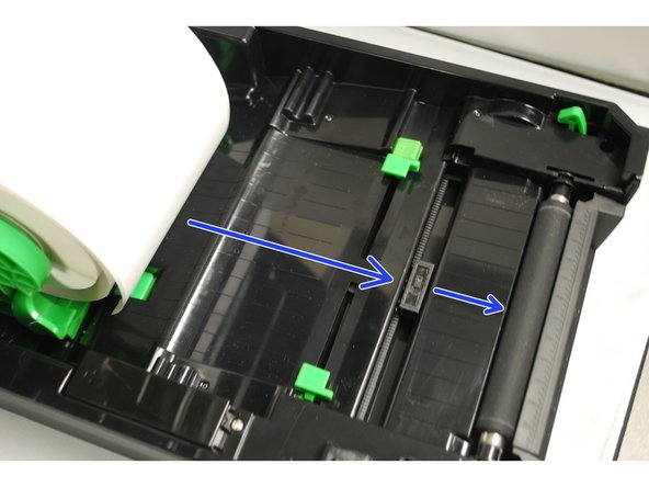 Place the paper, printing side face up, over the media sensor and place the label leading edge onto the platen roller (the rubberized roller near the the front of the printer).