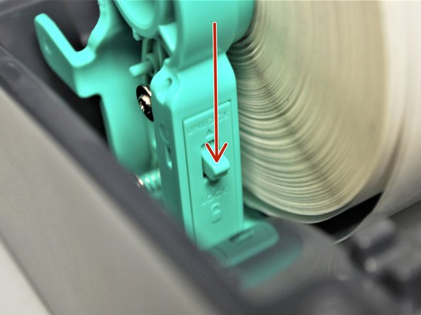 While holding the labels in place, use your other hand to push the holders together, so that they hold the roll of labels.