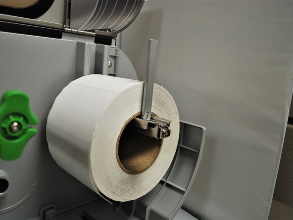 Fold the label roll guard back up and and press it against the side of the roll.