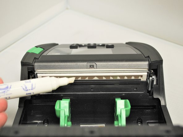 Uncap the cleaning pen and use the tip to clean the glass surface of the print head, ensuring there is no label or ribbon residue, or dust or other particulate.