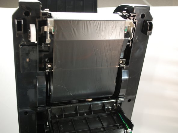 Turn the ribbon rewind gear until the ribbon plastic leader is thoroughly wound.