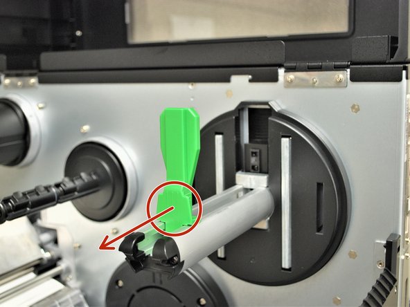 Locate the green label roll guard pictured and pull away from the printer.