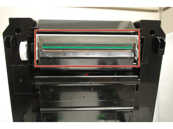 To release the top cover, use a finger to pull forward (towards the front of the printer) on each of the green releases latches, located on either side of the printer. Once released, gently lift the cover all the way up.