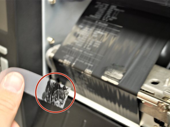 Put the piece of tape on the ribbon.