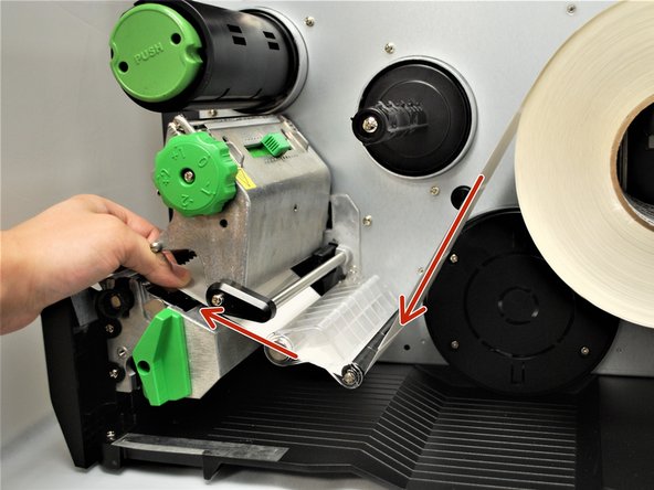 Feed the labels under the damper roller (1st picture).