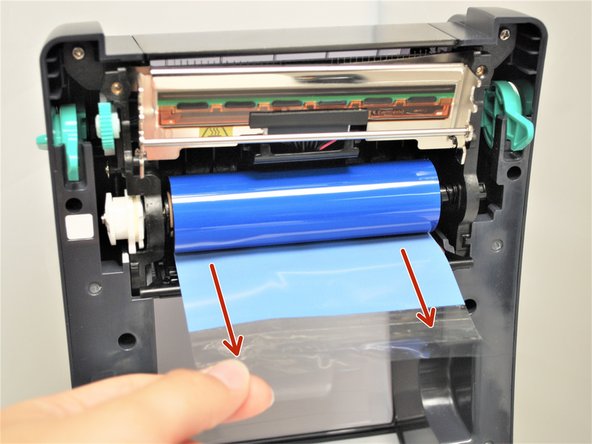 Now that the ribbon is mounted, pull on the plastic tab to unwrap the ribbon.