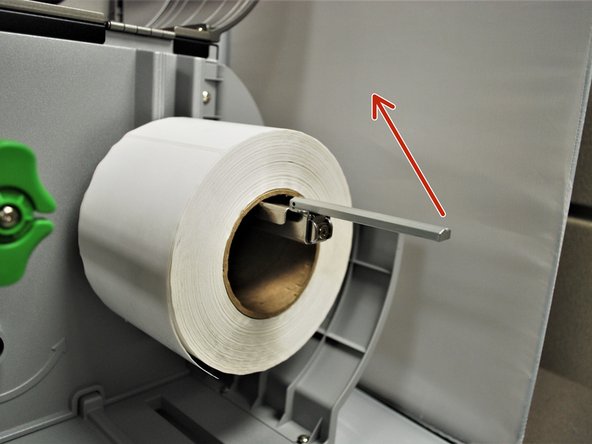 Place the roll of labels on the spindle, so that they unroll from the top.