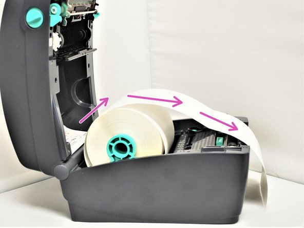 Take the leading edge of the labels, and pull it out past the front of the printer.