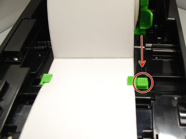 Move the media guides (the small green tabs) to fit the label width by pushing the media guide adjustment button.