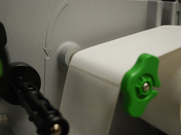 Feed the labels over the media guide bar (1st picture), and under the damper roller (2nd picture).