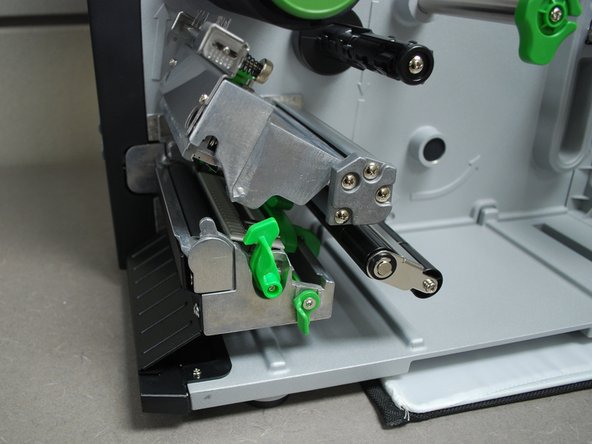 With the other, push the green release lever to the right.