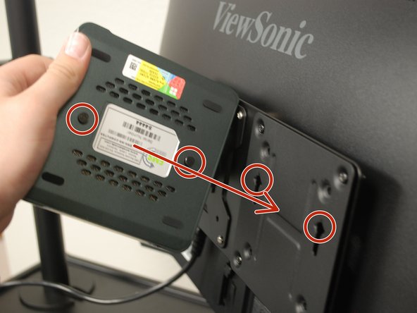 Insert the metal pegs on the bottom of the PC into the holes of the mount plate.