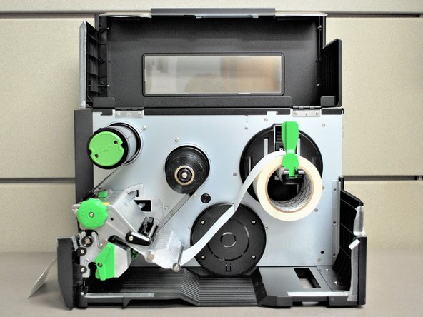 Close the printhead by pressing down firmly on top until you hear a 'click,' making sure that the green print head release lever is latched closed.