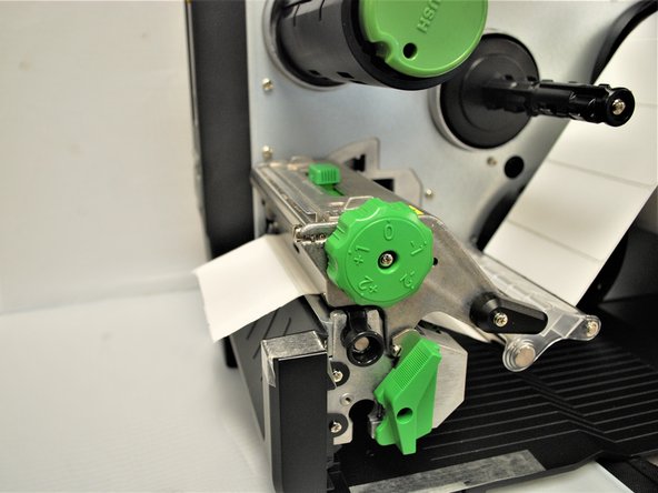 Close the printhead by pressing down firmly on top until you hear a 'click,' making sure that the green print head release lever is latched closed.
