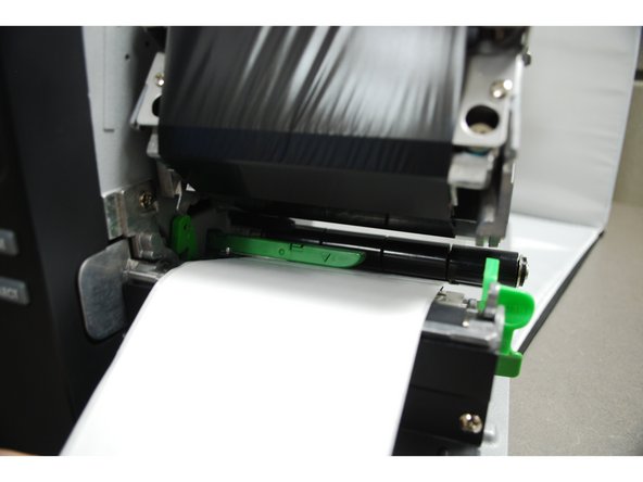 Pull through until the leading edge of on label is even with the platen.