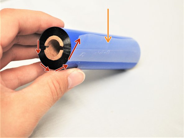 Identify the plastic tab (shown by the orange arrow) on the ribbon and which way the ribbon is wound around the core (shown by the red arrow), as shown in Image 1.
