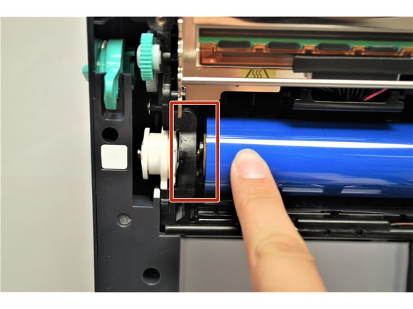 Be sure to keep the plastic tab on the bottom and  while having the ribbon being fed towards you, shown by the yellow box.