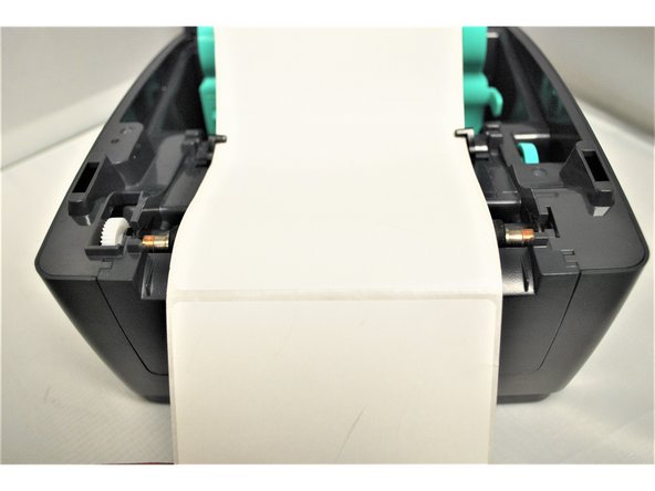 Pull the labels forward until the perforated border between labels line up with the tear off edge of the printer.