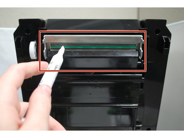 Uncap the cleaning pen and use the tip to clean the glass surface of the print head, ensuring there is no label or ribbon residue, or dust or other particulates.