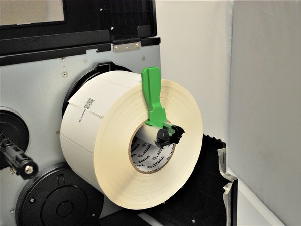 Press the label roll guard against the side of the roll.
