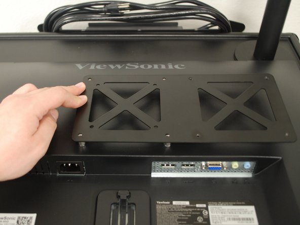 Twist the metal spacers into the 4 holes in the back of the monitor.