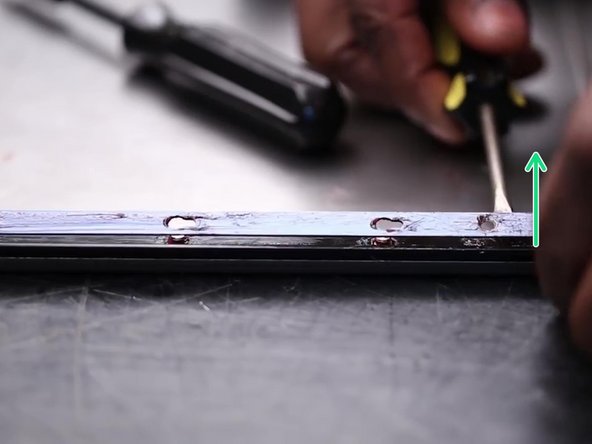 Pry the retaining strip up away from the standoffs.