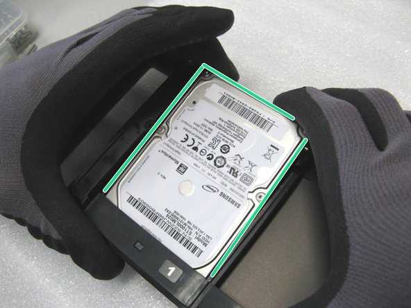 Die mit Schrauben versehenen Festplatten vorsichtig einsetzen. Darauf achten, dass die Schraube in dem Aufnahmeschlitz zum liegen kommt.