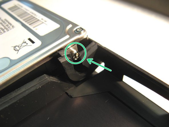 Die Festplatte mit Hilfe der oberen Plastikabdeckung nach unten drücken bis sie einrastet.