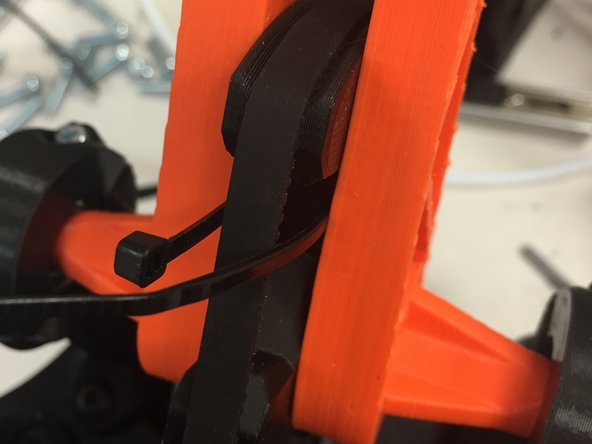 Insert the proprietary belt-tensioning mechanism through the slots in the 3D0002b pulley.