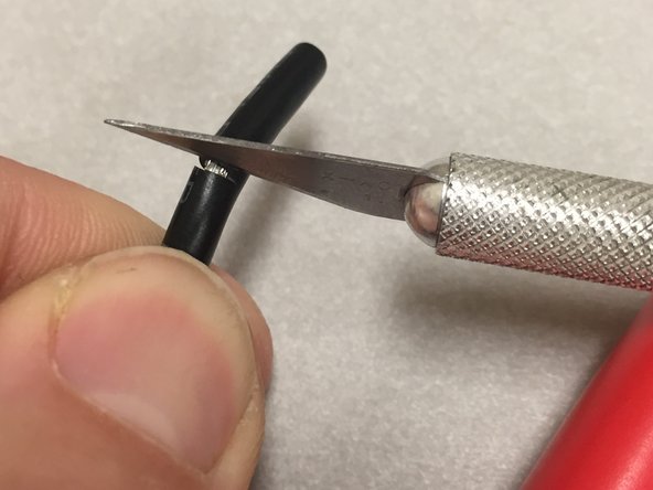 The safest and easiest way to do this is with a X-acto style razor blade.  Bend the cable slightly at the 20mm mark.  Cut the outside jacket with the razor blade, VERY CAREFULLY, with just enough pressure to cut through the jacket, without cutting into the wires.