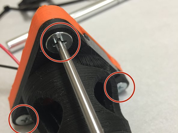 Insert three M5 flat-head machine screws (12mm long) as shown in the picture.  When screwed in, they should engage with the M5 nut on the opposite side.
