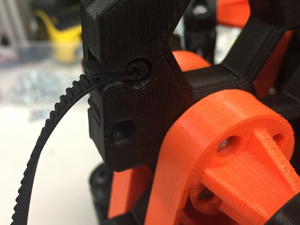 Slide the belt into the pulley, in the round hole slot, as shown.