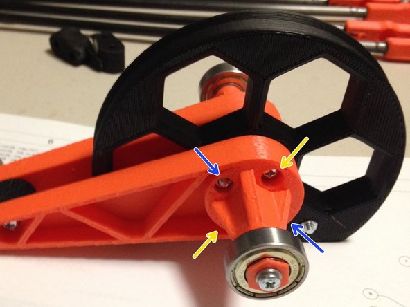 Insert two M3 nuts into each orange arm, as shown in the second picture.  NOTE: Only two of the holes will accept nut traps.